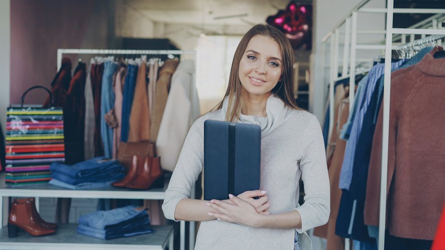Dueña de una tienda de ropa entre sus percheros