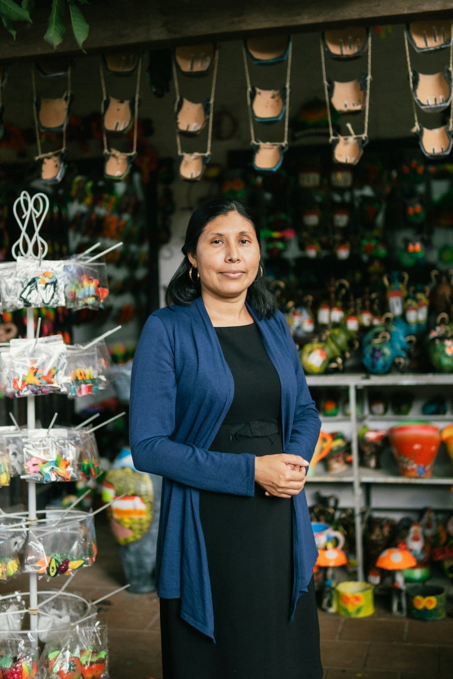 Dueña de una tienda de artesanías frente a sus estantes